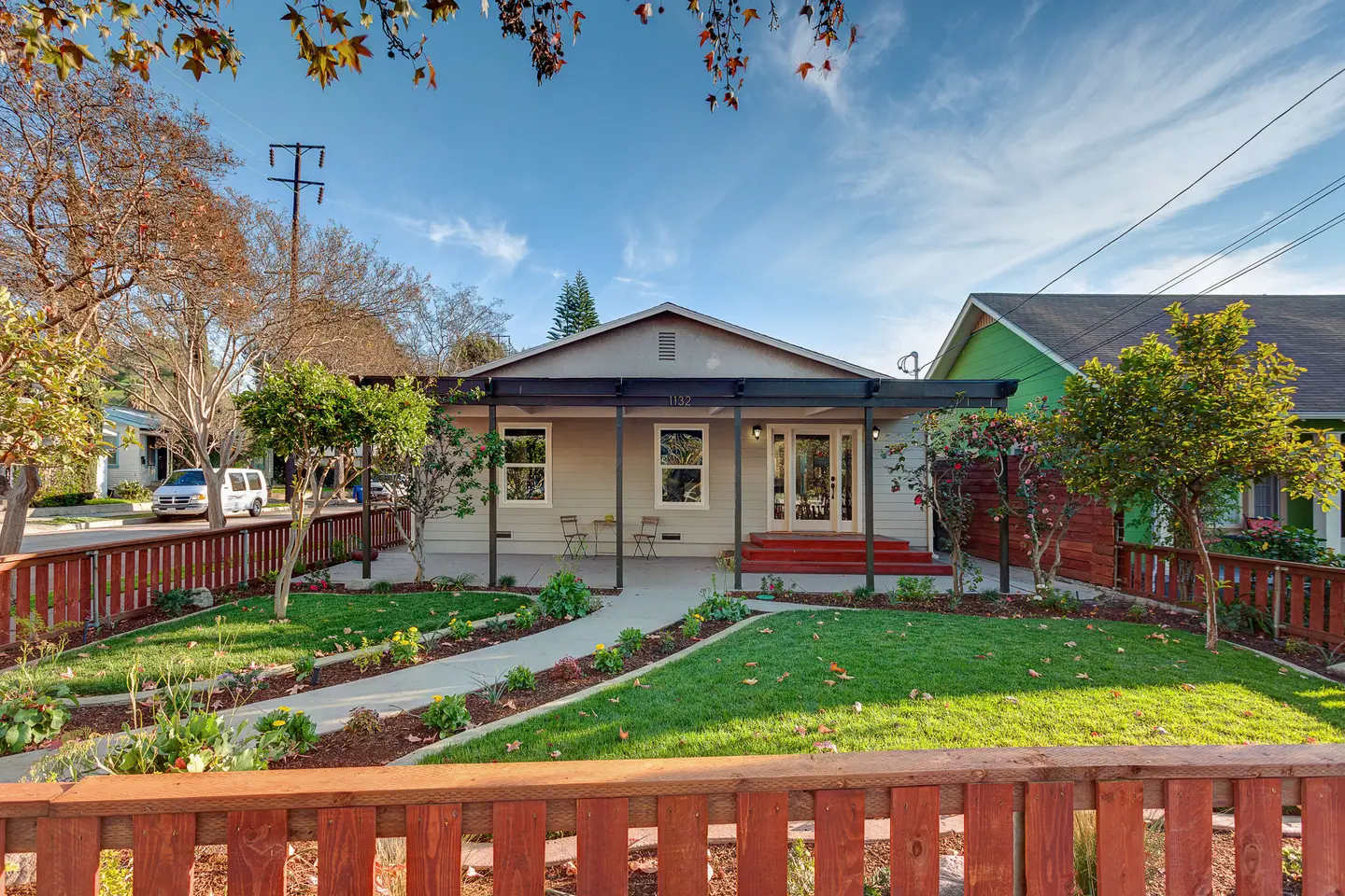 A Craftsman-style bungalow with a red fence and garden in Eagle Rock